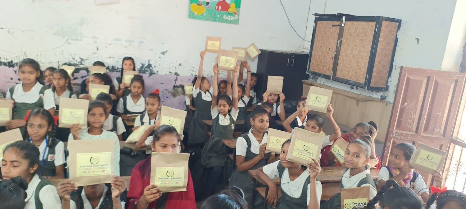 Schoolgirls holding dignity kits
