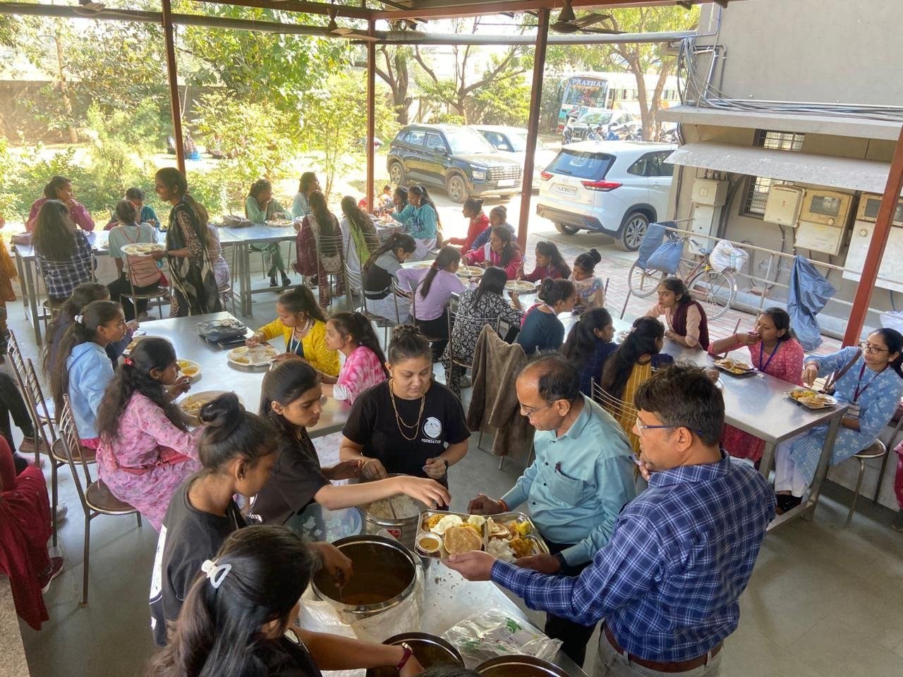 Children seated in a circle eating a hot meal